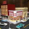 A look 'Downtown': There's a pretty nice area for folks to shop around in town on our home-based layout.  The donut shop (with its custom Krispy Kreme interior) is right on the corner, up the street from both the Five and Dime and the town's bank.  Lots of detail here.