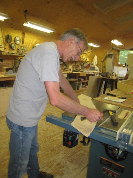 Roy in carpentry shop holding river