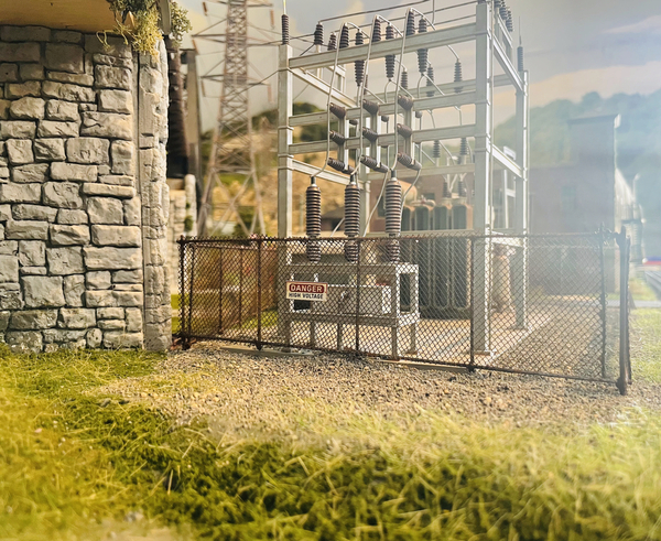 Closer view of Woodland Scenics substation with chain link fence around it