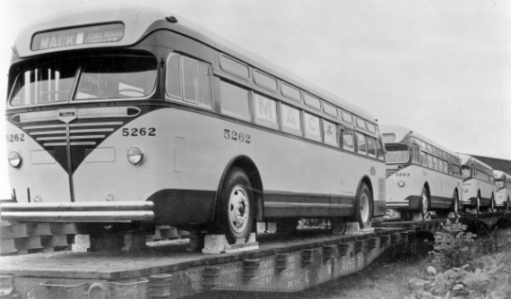 Mack buses on flat cars